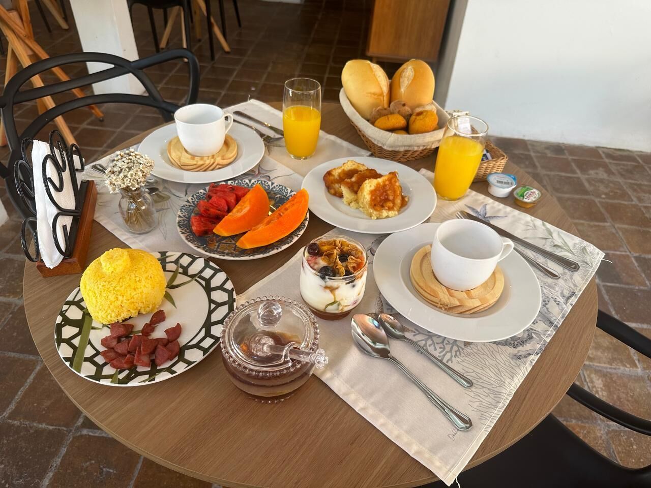 A breakfast table with various dishes including pancakes, scrambled eggs, and fresh fruit.