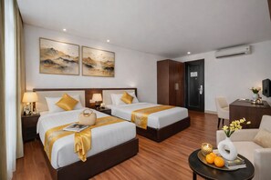 A hotel room with two beds, a desk, a chair, and artwork on the wall. - Sapphire Hotel (Da Nang Municipality)