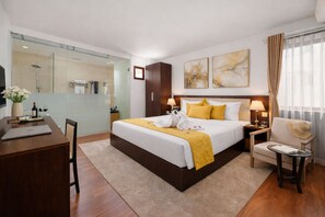 A hotel room with a bed, bedside tables, a desk, a chair, a mirror, and artwork on the wall. - Sapphire Hotel (Da Nang Municipality)