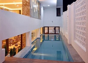 Una piscina cubierta, una piscina al aire libre