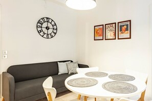 A modern living room with a round table, a sofa, and a wall clock.