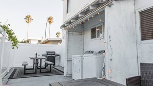 A patio with outdoor furniture, a grill, and a washing machine. - Spacious 2BR | Patio + Sleeps 6 | Steps to Beach (Oceanside)