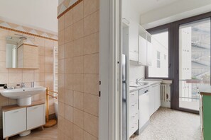 A modern bathroom with a sink, mirror, and toilet.
