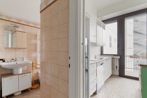 Un baño moderno con lavamanos, espejo y retrete.