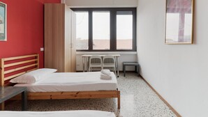 A room with two beds, a desk, chairs, a window, and a painting on the wall. - GuestHost - Farini Apartment for 6 people Milan (Milan)
