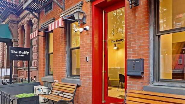 A brick building with a red door and a sign reading "The Duffy by kasa". - Kasa the Duffy Times Square (New York)