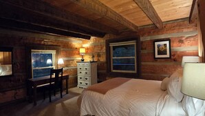 A cozy log cabin bedroom with a bed, a desk, and a chair. - Peaceful Mountain Cabin over 4,600 ft elevation (Zionville)