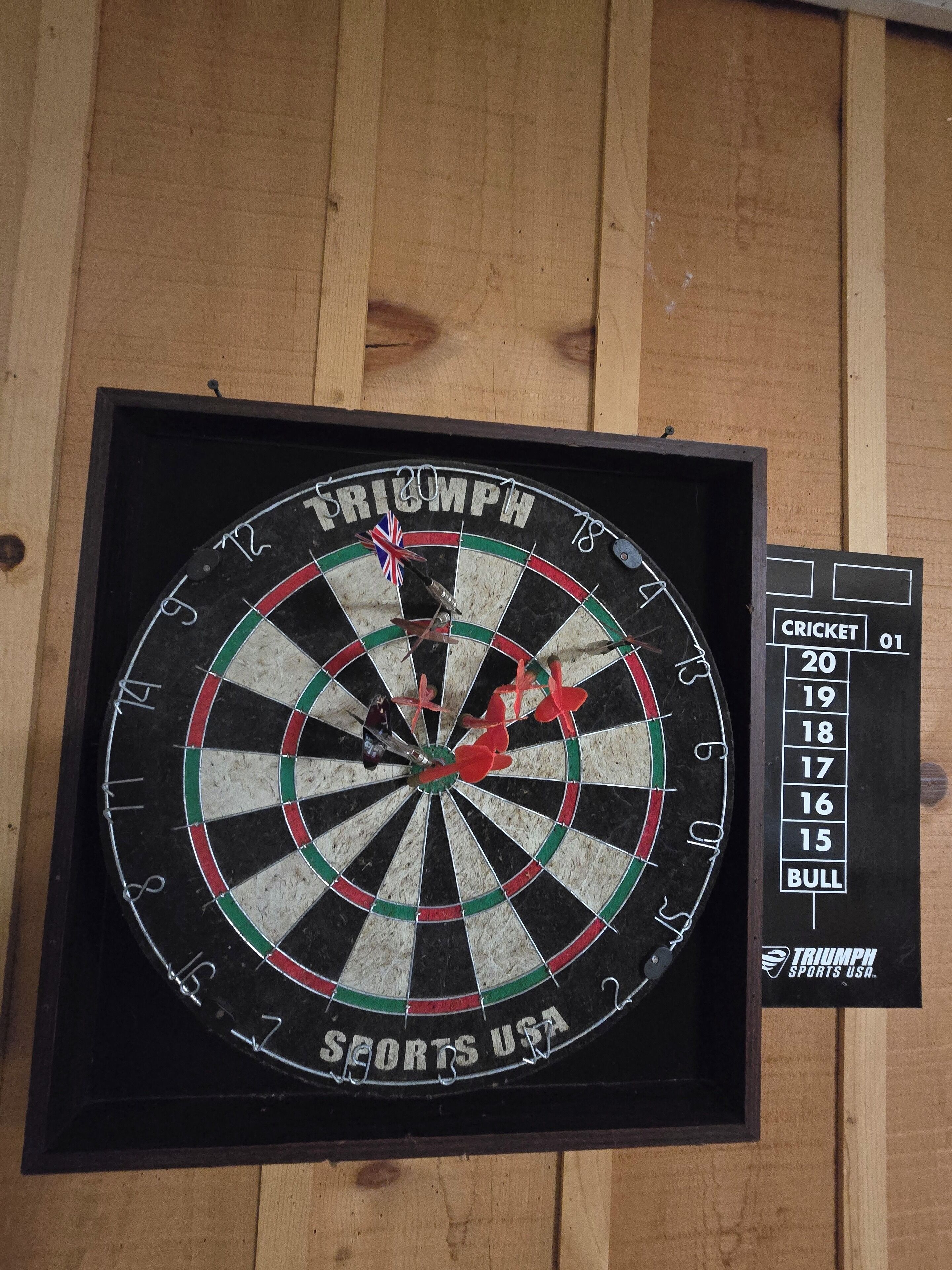 A dartboard with a score chart beside it.