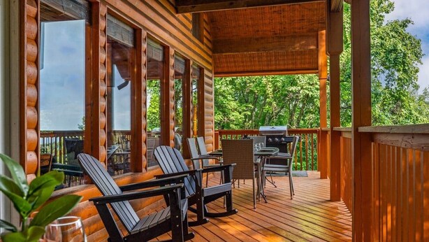 A wooden deck with outdoor seating, a grill, and a view of trees. - Legends Lookout! Mtn Views, Bear sightings & More (Gatlinburg)
