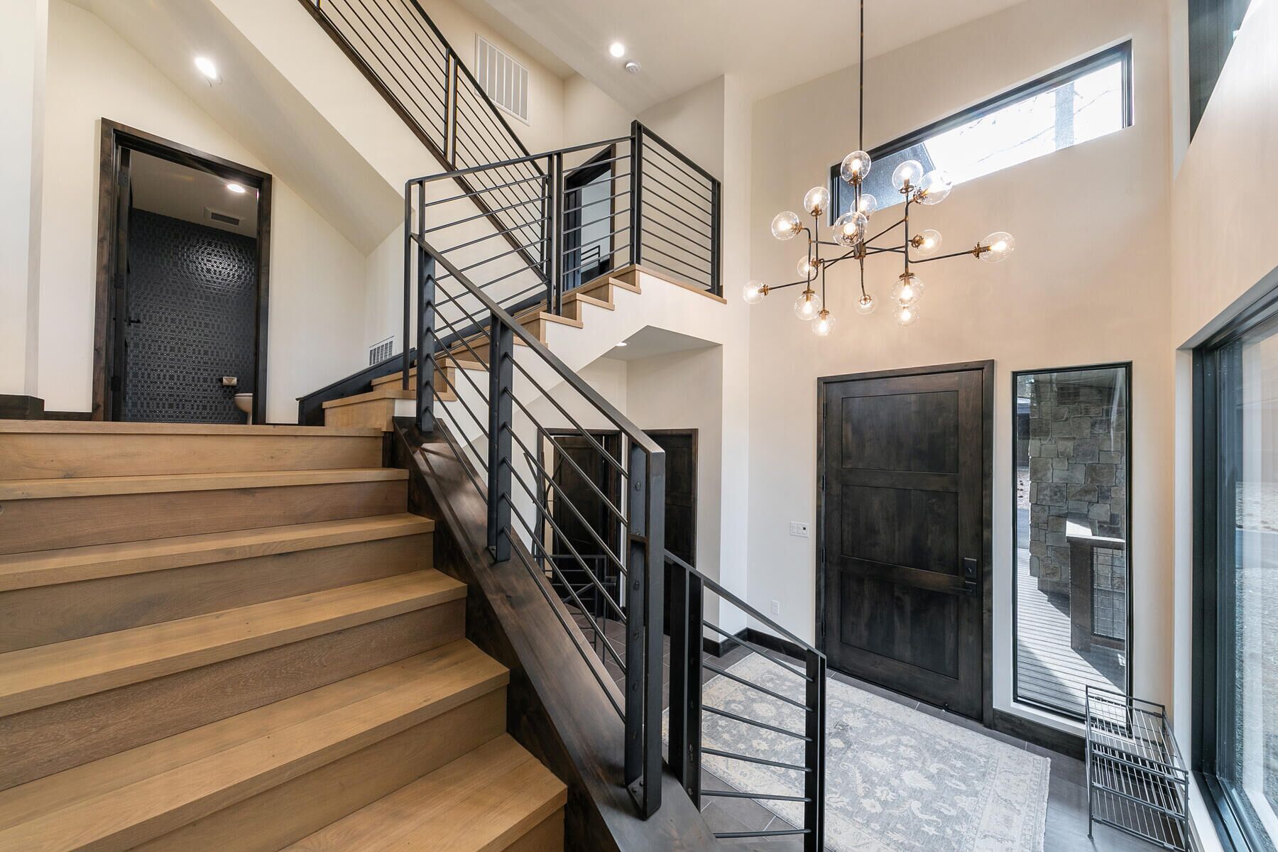 A staircase with wooden steps and black railings, leading to an upper floor.