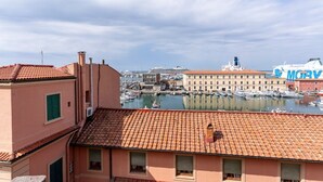 Un puerto deportivo con barcos, un edificio con techo de tejas rojas y un cartel grande con la inscripción 'MGM'.