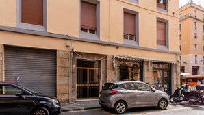 Un edificio con una puerta de garaje cerrada, un coche aparcado y una motocicleta.