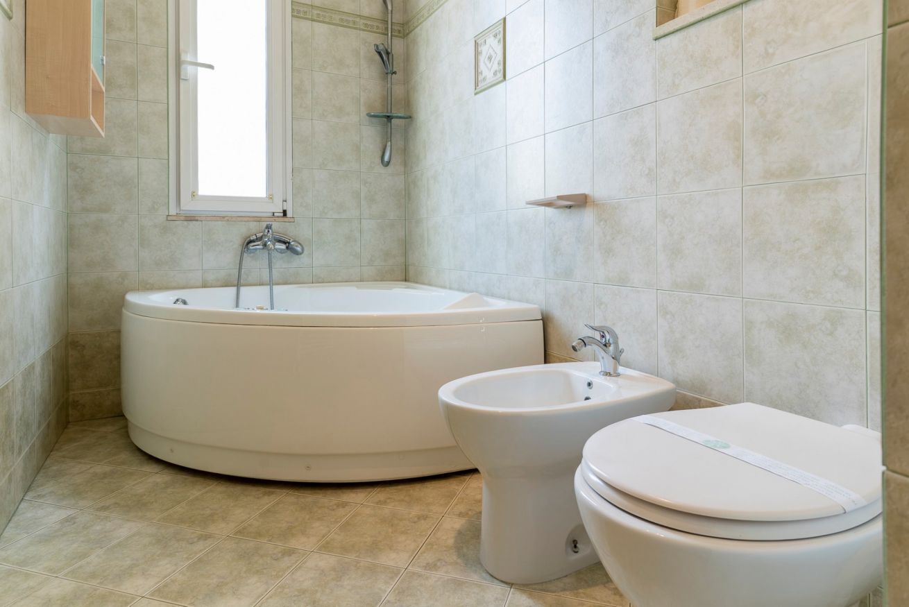 Un baño con bañera, bidé e inodoro.