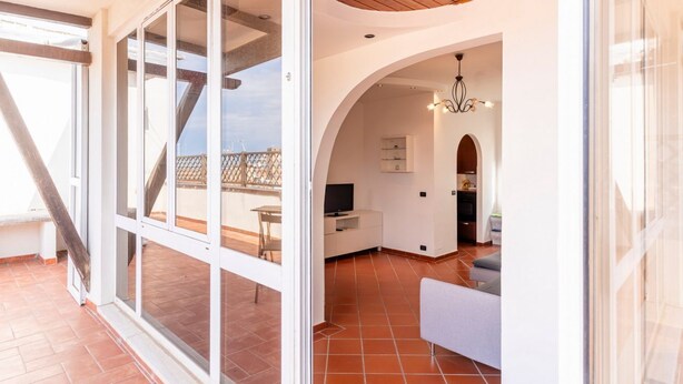 Un interior moderno con comedor, cocina y un balcón con vistas.