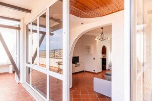 A modern interior with a dining area, kitchen, and a balcony with a view.