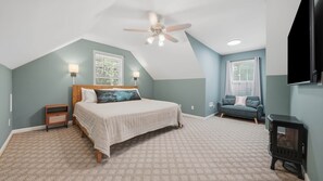 A bedroom with a bed, a ceiling fan, a TV, and a fireplace. - Secluded 10-acre villa, sleeps 18, hot tub! (Trenton)