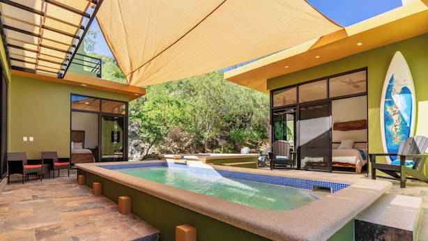 A pool area with a hot tub, outdoor seating, and a surfboard decoration. - 5BR/5B bath Los Barriles Retreat w/ Pool, Hot Tub & Sea of Cortez Views (Buenos Aires)