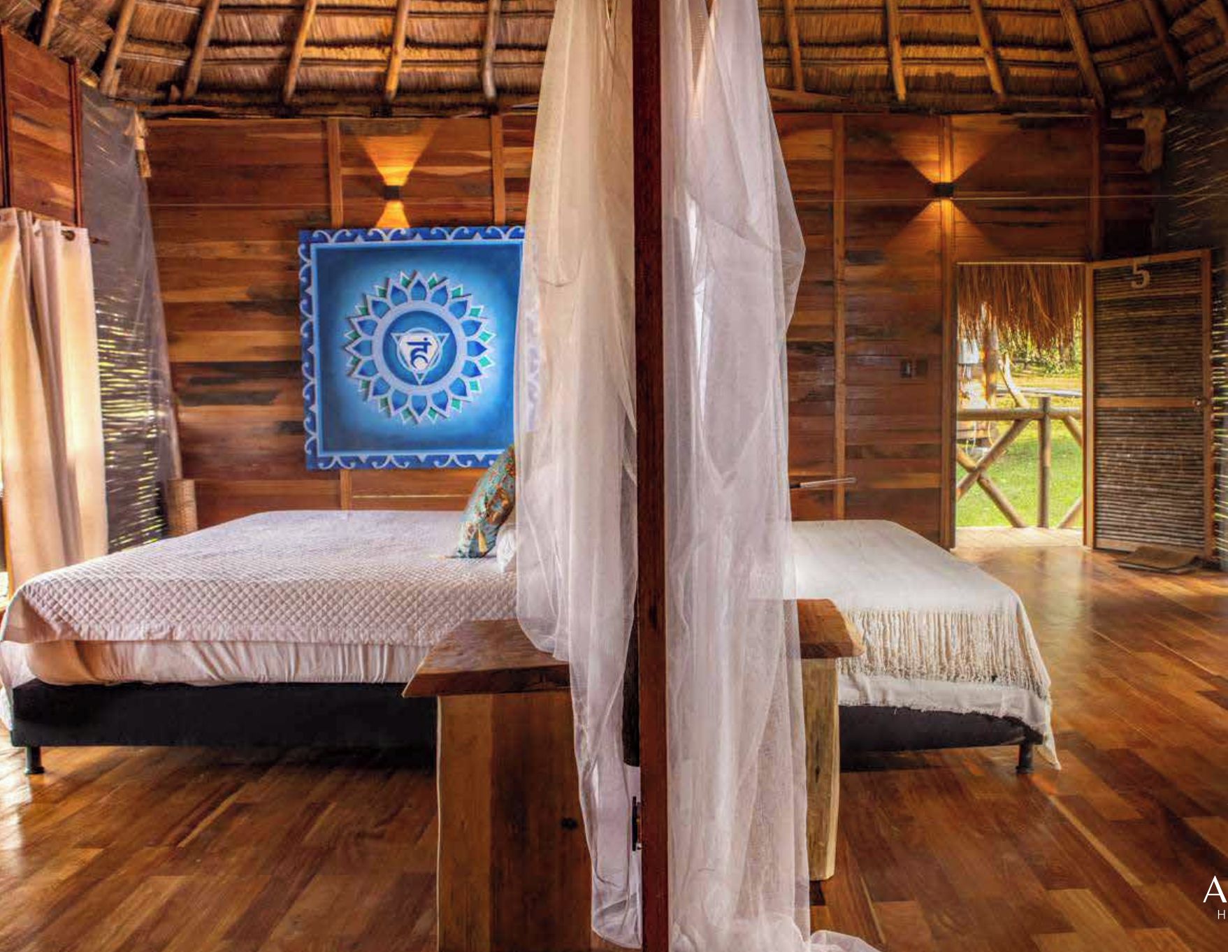 Um quarto de madeira com uma cama, uma mesinha e uma parede com um padrão azul e branco.