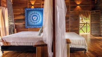 Um quarto de madeira com uma cama, uma mesinha e uma parede com um padrão azul e branco.