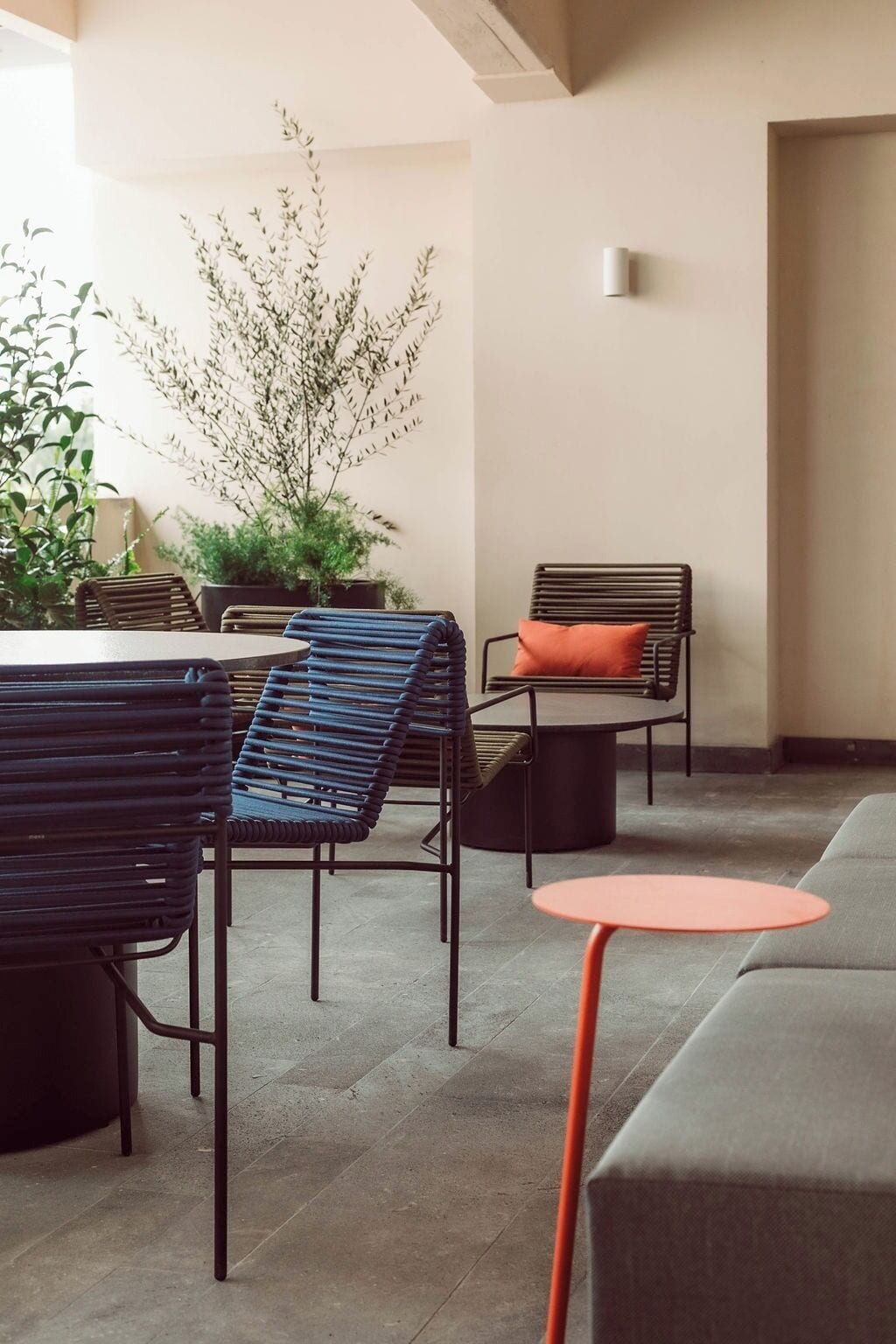 Ein moderner Lounge-Bereich mit Sitzgelegenheiten, einem Topfpflanzen und einer Wandleuchte.