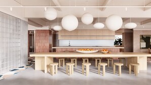 Une cuisine moderne dotée d’un îlot central, de luminaires suspendus et d’un coin repas avec des tabourets.