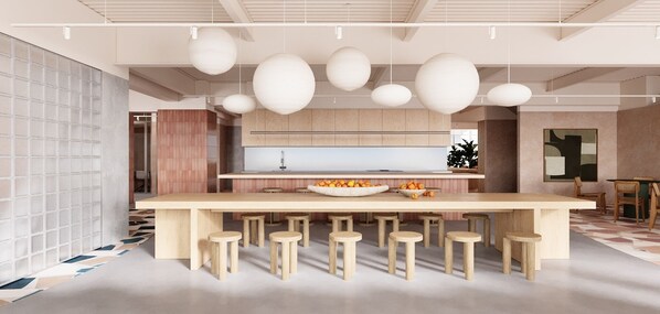 Una cocina moderna con una isla central, lámparas colgantes y una zona de comedor con taburetes.