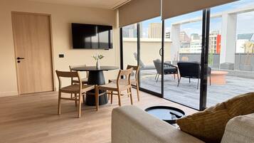 Departamento de lujo, Terraza, vista a la ciudad | Área de sala de estar | Televisión de pantalla plana de 55 pulgadas con canales por cable