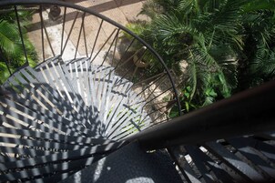 Una escalera de caracol con barandas de metal y vistas de la vegetación circundante.
