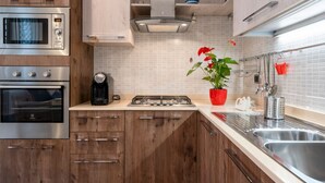 Eine moderne Küche mit Edelstahlgeräten, Holzschränken und einer gefliesten Spritzschutzwand.