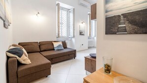 Ein modernes Wohnzimmer mit einem braunen Sofa, einem Holztisch und einem Glas Wasser.