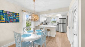 A modern kitchen with a central island, white cabinetry, and stainless steel appliances.