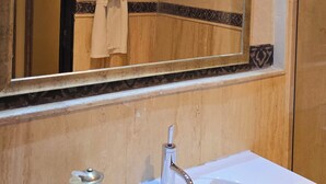 Un bagno con uno specchio grande, un lavabo e un asciugamano appeso al muro.