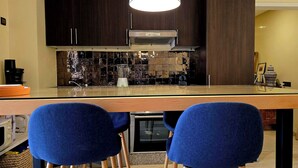 Una cucina moderna con mobili in legno scuro, un'isola in vetro e un forno integrato.