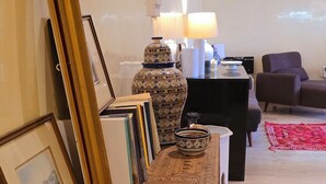 Una stanza con un lungo tavolo consolle in legno, uno specchio grande e un tappeto decorato.
