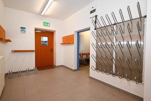 A hallway with a wooden door, a metal rack, and a blue wall.