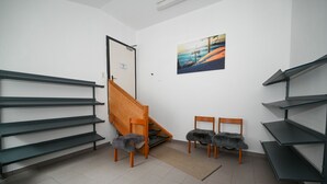 Ein Zimmer mit einer Holztreppe, zwei Sesseln mit Felldecken und einem Gemälde an der Wand.