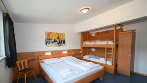 Ein Hotelzimmer mit einem großen Bett, einem Holzbettstapel, einem Stuhl und einem Bild an der Wand.