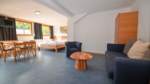 Ein modernes Wohnzimmer mit Esstisch, Sofa und einem kleinen Couchtisch.