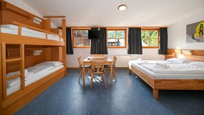 Ein Zimmer mit Etagenbetten, einem Schreibtisch und einem Bett.