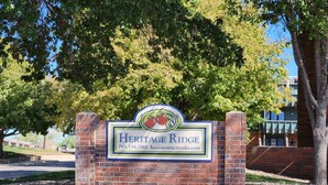 En entré av tegel med en skylt som visar texten ”Heritage Ridge” och ett telefonnummer.