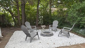 A patio area with Adirondack chairs and a circular fire pit surrounded by white pebbles. - 4 Blocks to the Erie Beaches (Millcreek Township)