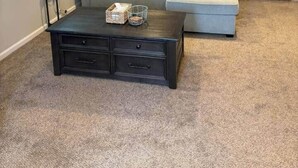 A living room with a sectional sofa, a dark coffee table, and a staircase leading to an upper level. - 4 Blocks to the Erie Beaches (Millcreek Township)