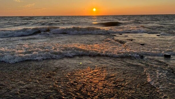 A beach at sunset with waves crashing onto the shore and a clear sky. - 4 Blocks to the Erie Beaches (Millcreek Township)
