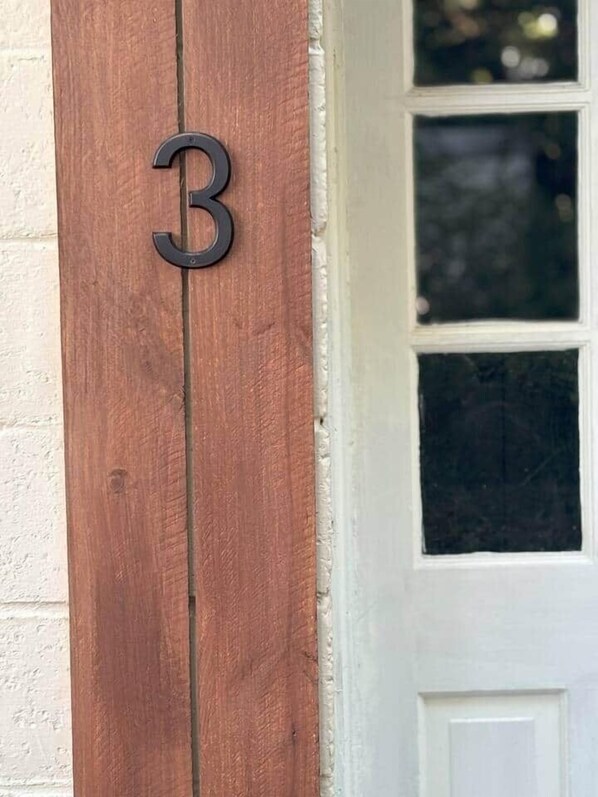 A wooden post with a metal number '3' sign.