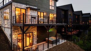 A multi-story house with stone and wood exterior, balconies, and outdoor seating areas. - Pool w/ a grotto!/Hot Tub/Game Room/Rooftop Deck - Appalachian Falls (Sevierville)