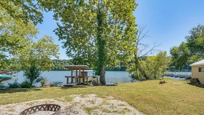 Une propriété située au bord du lac, dotée d’une terrasse, d’un foyer extérieur et offrant une vue sur le lac.