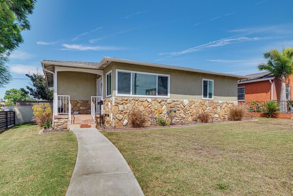 A two-story house with a stone facade, a covered porch, and a well-maintained lawn. - 4 Mi to SoFi Stadium: Modern Home w/ Fenced Yard (Los Angeles)