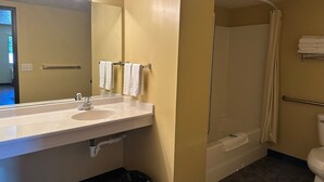 A bathroom with a sink, mirror, towel rack, shower, and toilet. - Elgin Sleepin Inn (Elgin)