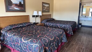 A hotel room with two beds, a wooden headboard, a nightstand with lamps, and framed pictures on the wall. - Elgin Sleepin Inn (Elgin)