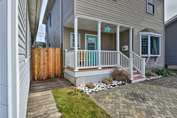 Covered front porch with white railings, a teal door, and a paver driveway. - ‘The 1818’ - Quick walk to 20th Ave Beach! (Lake Como)